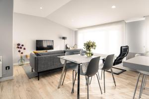 a living room with a table and chairs and a couch at APARTAMENTO PEDRADOURO in Malpica