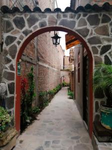 an alley with an archway in a stone building at MESONERO in Ayacucho
