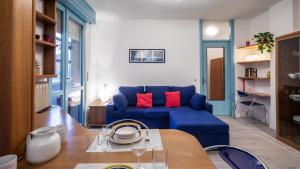 Una sala de estar con un sofá azul y una mesa. en Via Leonardo Da Vinci 135 - Piano Terra, en Udine