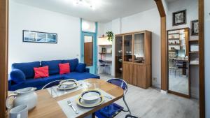 un soggiorno con divano blu e tavolo di Via Leonardo Da Vinci 135 - Piano Terra a Udine