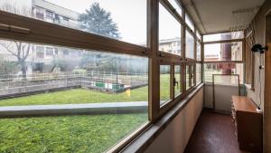 ein leeres Klassenzimmer mit einem großen Fenster mit Blick auf einen Hof in der Unterkunft Via Leonardo Da Vinci 135 - Piano Terra in Udine