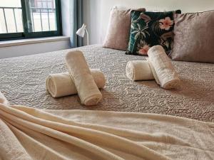 a bed with two rolled up towels on it at Downtown Apartment (center) in Setúbal