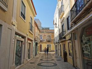 a couple of people walking down a street at Downtown Apartment (center) in Setúbal