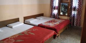 哈里瓦的住宿－Goroomgo Gayatri Guest House Near Haridwar Railway Station，小客房内的两张床,配有红色床单