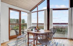 comedor con mesa, sillas y ventanas en Gorgeous Home In Allingbro With Kitchen en Allingåbro