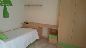een kleine slaapkamer met een bed en een bureau bij GRANJA-CLIMATIZADO-Parking gratis in Jaén
