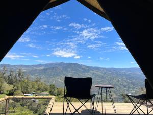 喬阿奇的住宿－Cúspide，帐篷设有两把椅子和一张桌子,享有美景。