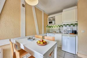 una cocina con una mesa con un bol de fruta. en Residence Pierre & Vacances Les Embruns en Deauville