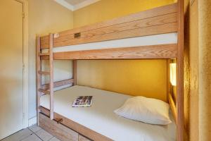 a bunk bed with a book on the bottom bunk at Residence Pierre & Vacances Les Embruns in Deauville