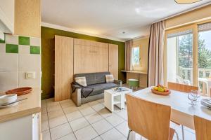 a kitchen and living room with a couch and a table at Residence Pierre & Vacances Les Embruns in Deauville
