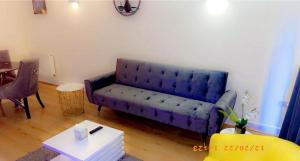 a living room with a blue couch and a table at Solonzo apartment in North Woolwich