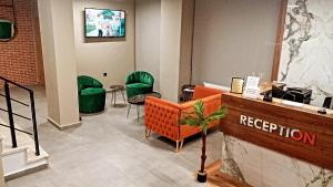 a lobby with green chairs and a reception desk at Fidanoğlu Suite Hotel Çorlu in Corlu