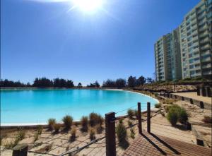 una gran piscina de agua azul junto a un edificio en Departamento full equipado - con laguna artificial lo mejor del litoral, en Las Cruces