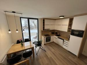 a kitchen with a table and a dining room at Apartmán 1000 m n. m. in Stachy