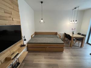 a bedroom with a bed and a dining table at Apartmán 1000 m n. m. in Stachy