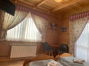 sypialnia z 2 łóżkami, stołem i oknem w obiekcie Dom Wypoczynkowy U Kubusia w mieście Białka Tatrzanska