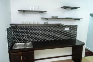 a black counter with a sink in a room at Abbi Holiday Service Apartment in Jaffna