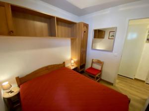 a bedroom with a red bed and a red chair at Chalet Jonquille in Valfréjus