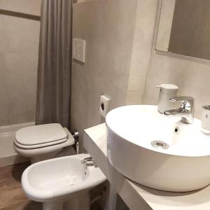 uma casa de banho com um lavatório branco e um WC. em Hotel Convertini em Milão