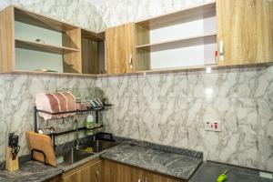 uma cozinha com um lavatório e uma bancada em Carve Out A Great Life At Our 2-Bed-Apartment FAST Wi-Fi & 24hrs Power em Amuwo