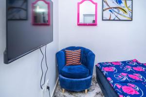 a blue chair and a couch in a room at Carve Out A Great Life At Our 2-Bed-Apartment FAST Wi-Fi & 24hrs Power in Amuwo
