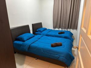 Duas camas com almofadas azuis num quarto em Kinta Riverfront by Mirath WiFi 500Mbps em Ipoh
