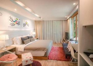 a bedroom with a bed and a living room at The Parlour Krabi in Klong Muang Beach