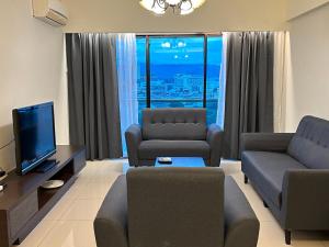 uma sala de estar com um sofá e uma televisão em Kinta Riverfront by Mirath WiFi 500Mbps em Ipoh