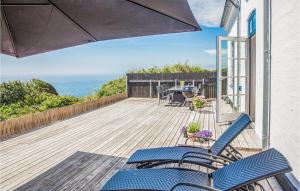 una terraza con sillas y sombrilla y el océano en Amazing Apartment In Sams With Wifi, en Kolby Kås