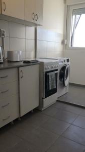 a kitchen with a stove and a washing machine at Newly equipped Arena apartment in Belgrade