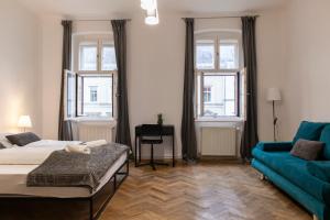 ein Schlafzimmer mit einem Bett und einem blauen Sofa in der Unterkunft Spacious 3BR Apt -Near Wiener Stadthalle BurggasseWiener Well Located in Wien