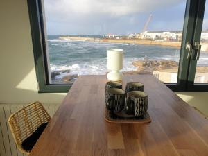 una mesa con vistas al océano desde una ventana en 180 degrés iodés, en Tréffiagat