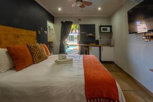 Un dormitorio con una gran cama blanca y una cocina. en Boma Lodge, en Durban 40 fotos más