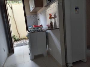 a small kitchen with a stove and a refrigerator at Navegantes Flats in Natal