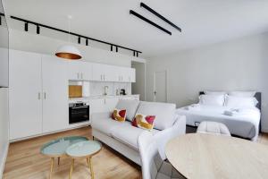 ein weißes Wohnzimmer mit einem Sofa und einem Bett in der Unterkunft Pick A Flat's Apartments in Opéra - Rue d'Hauteville in Paris