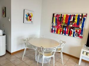 a table and chairs in a room with a painting at Vistala in Baveno