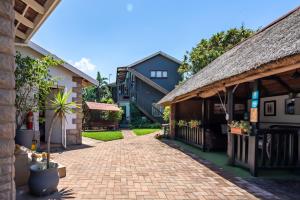 un patio de una casa con techo de paja en Boma Lodge, en Durban