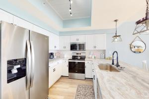 a kitchen with white cabinets and a stainless steel refrigerator at Majestic Sun 1111A Miramar Beach (Condo) in Destin