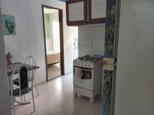 a kitchen with a stove and a table in it at Navegantes Flats in Natal