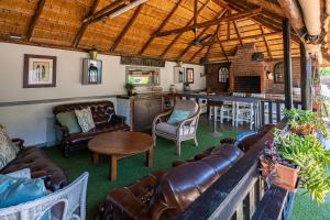 a living room with leather furniture and a kitchen at Boma Lodge in Durban