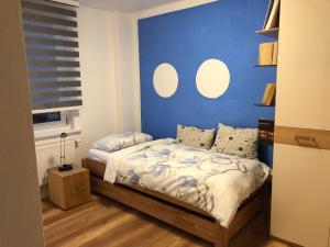 a bedroom with a bed with a blue wall at Ferienwohnung "Frieda" 