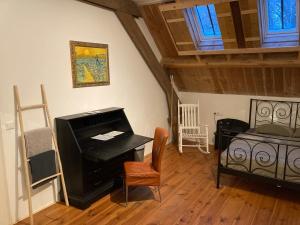 a living room with a piano and a bed at B&B de Bievangh in Breda