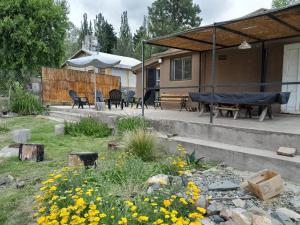 a patio with a table and chairs and flowers at AMORADA in Potrerillos