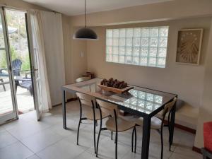 a dining room with a glass table and chairs at AMORADA in Potrerillos