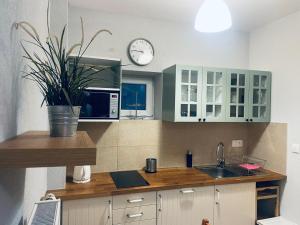 a kitchen with a sink and a clock on the wall at Penzion Rima in Zuberec