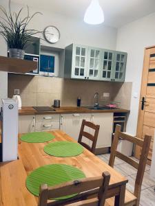 a kitchen with a wooden table with green mats on it at Penzion Rima in Zuberec