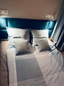 ツベレツにあるPenzion Rimaのベッド(白い枕、青いヘッドボード付)