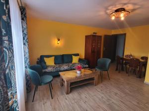 een woonkamer met een bank, stoelen en een tafel bij Apartamenty i Pokoje w Willi na Ubocy in Suche