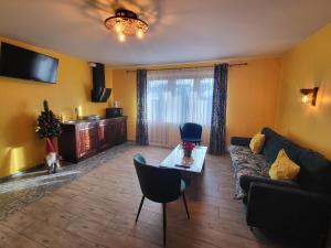 een woonkamer met een bank en een tafel bij Apartamenty i Pokoje w Willi na Ubocy in Suche