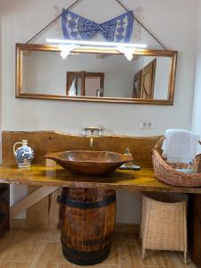 a bathroom with a wooden sink and a mirror at Pensiunea Casa Țărănească in Satu Bătrîn +43 photos